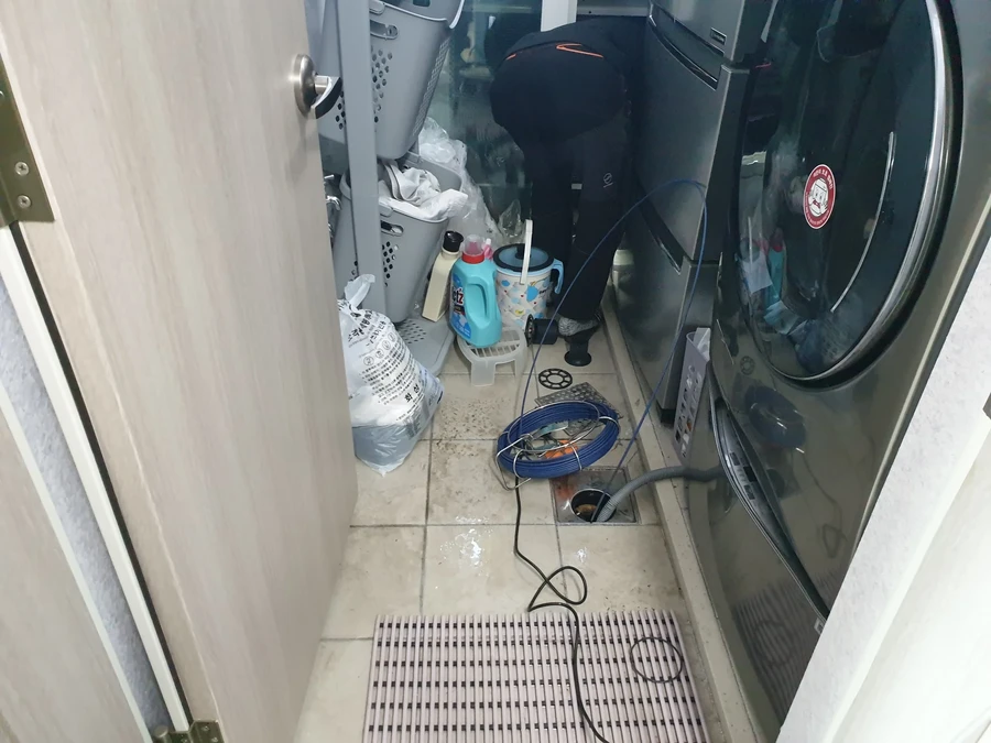 세탁실 바닥 배수구 옆에 놓인 점검 장비