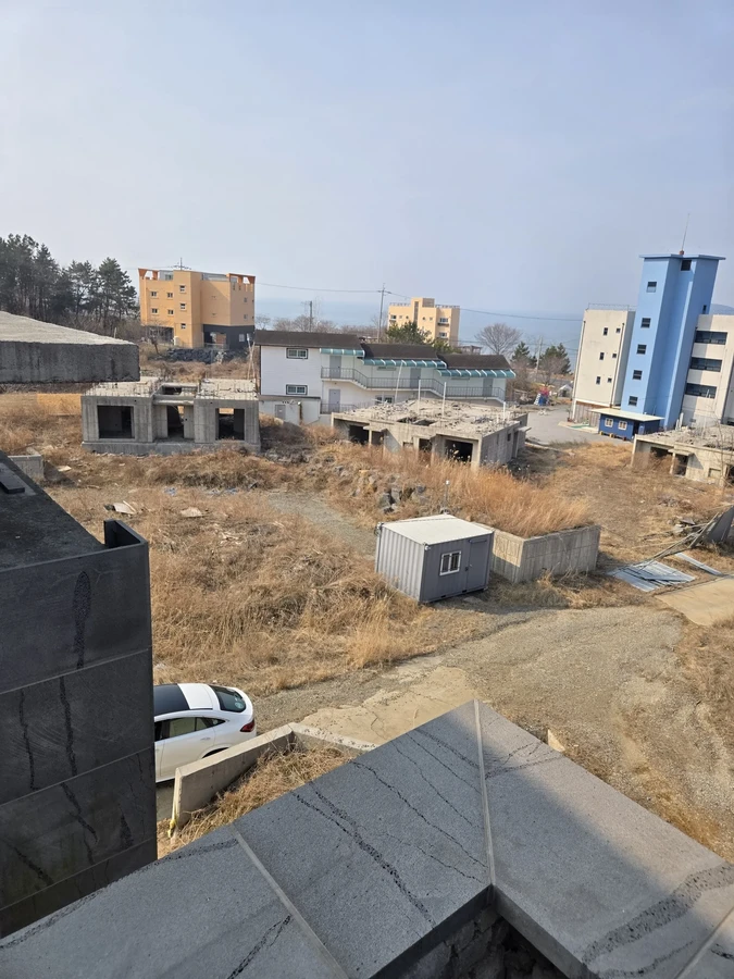 높은 위치에서 내려다본 주변 건물과 컨테이너, 마른 풀 부지