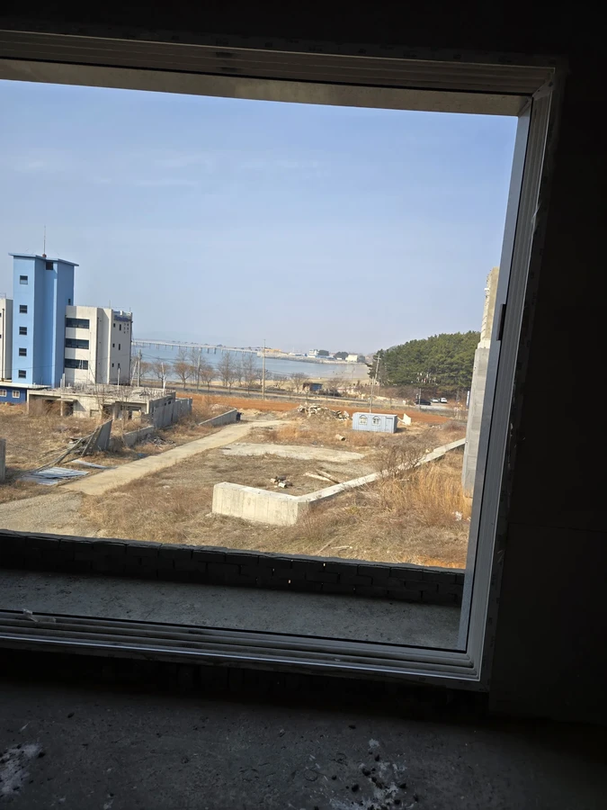 창틀 너머로 주변 건물과 부지가 내려다보이는 모습